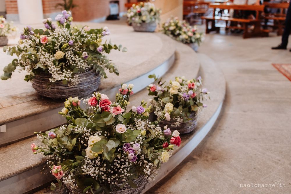 Beautiful floral arrangements with pink and white flowers decorate church steps.