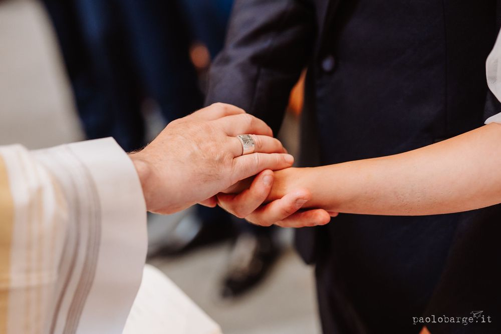 Close-up shot of hands exchanging wedding rings during the ceremony.