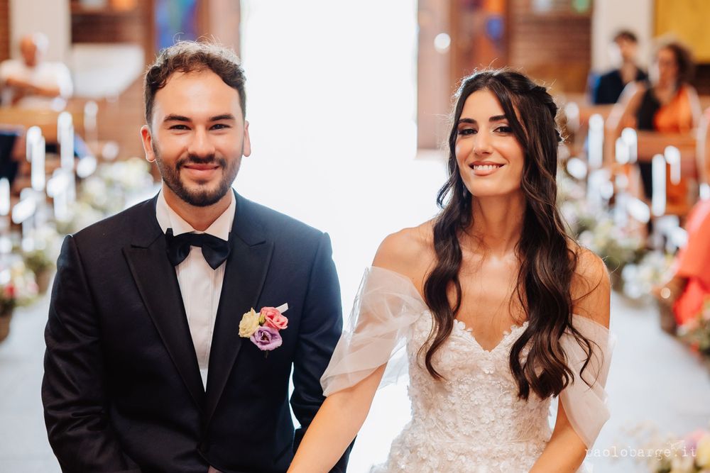 A joyful couple in formal wedding attire share a happy moment together during their celebration.