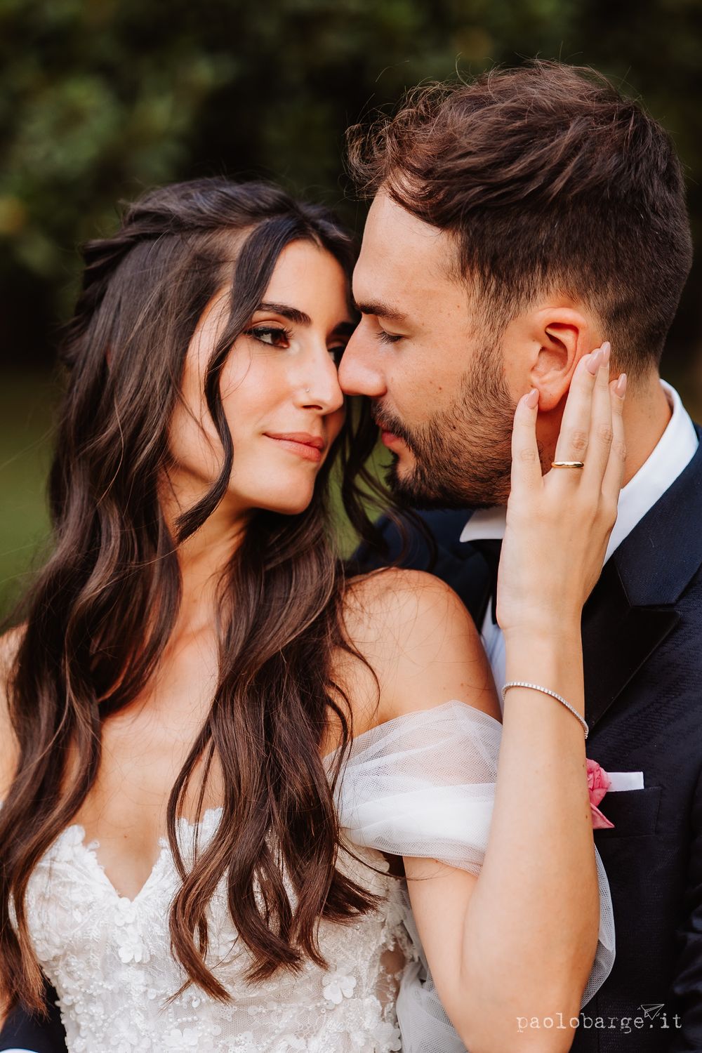 Close-up portrait of a couple sharing an intimate moment outdoors.