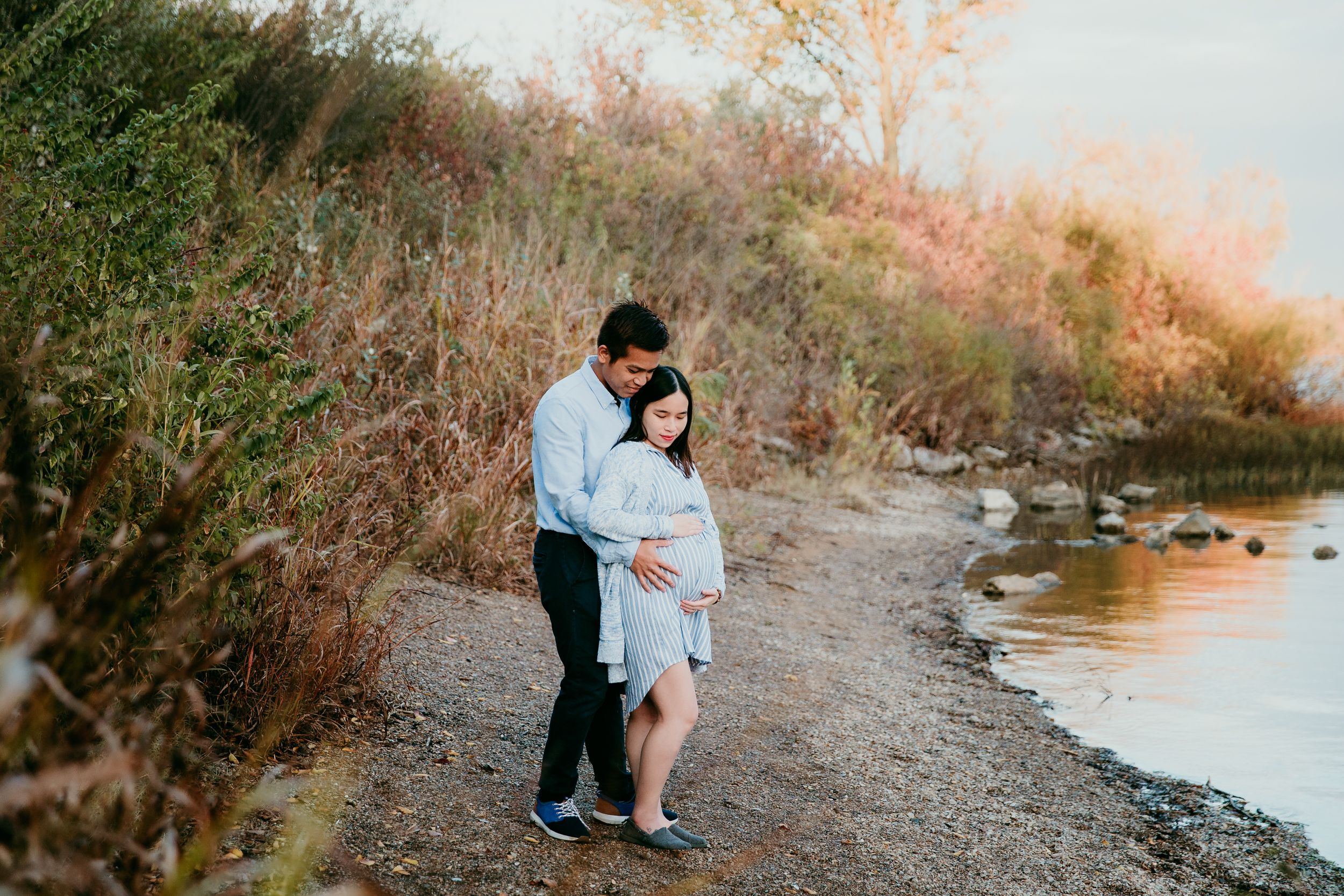 couple standing together with hands on woman's pregnant belly