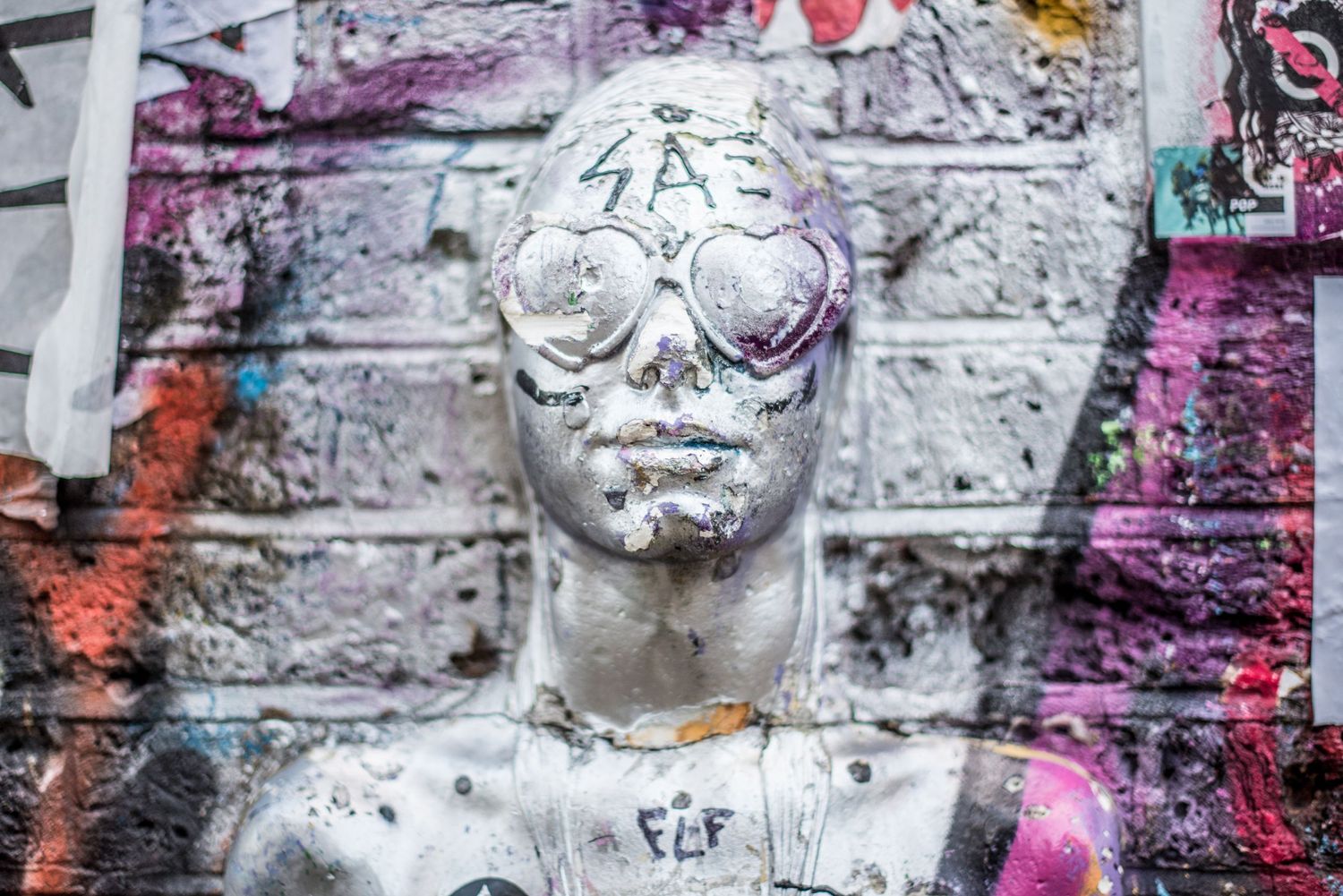 Cool street art of a silver statue with heart glasses spray painted silver in London's artsy Shoreditch neighborhood