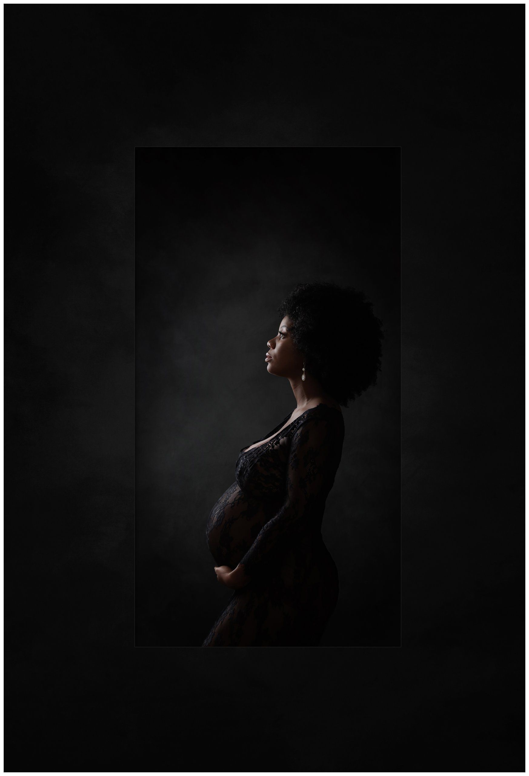 Profile maternity portrait of African mother with afro in black lace