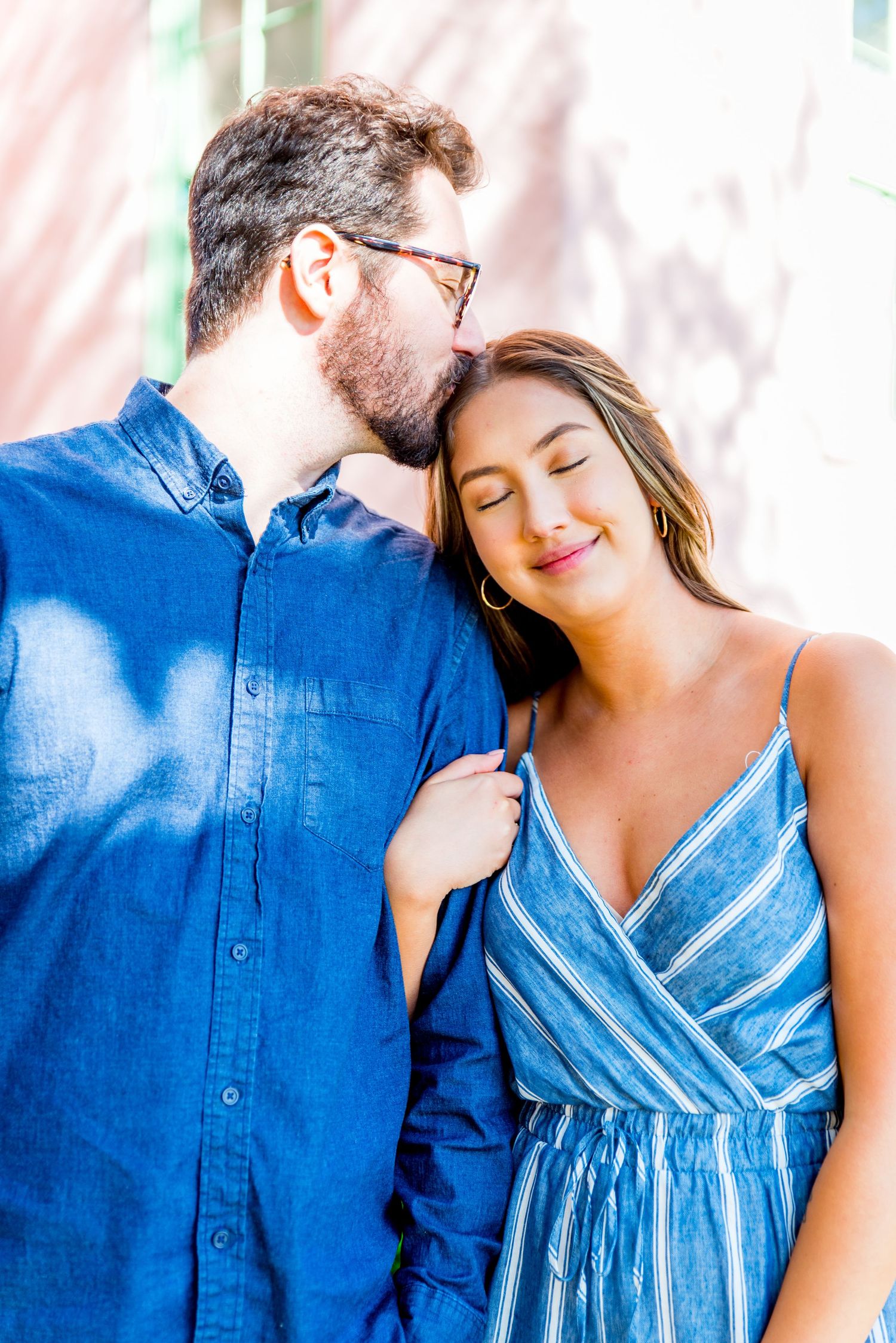 young man kissing head of young woman at Vinoy Park engagement photos in St. pete, Florida