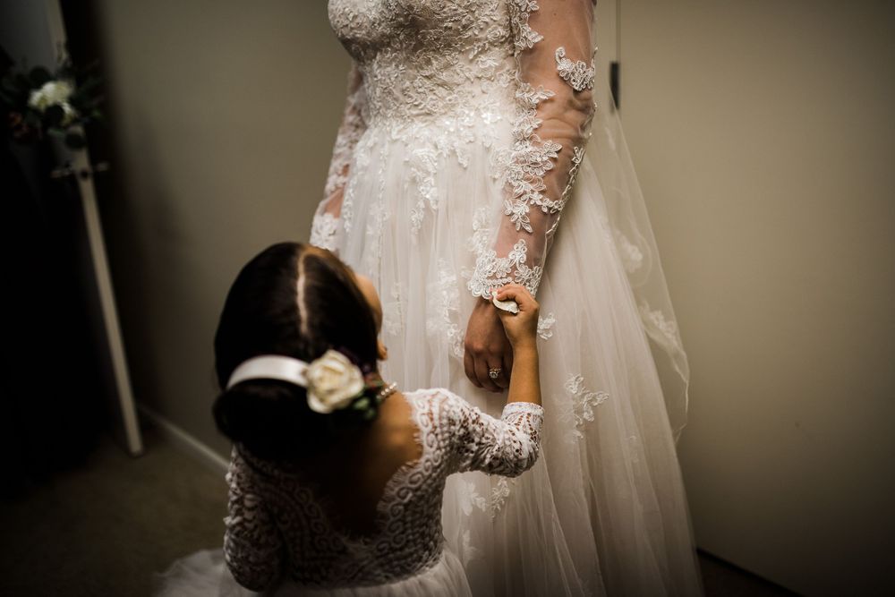 Flower girl looks up at bride by Hudson Valley photographer