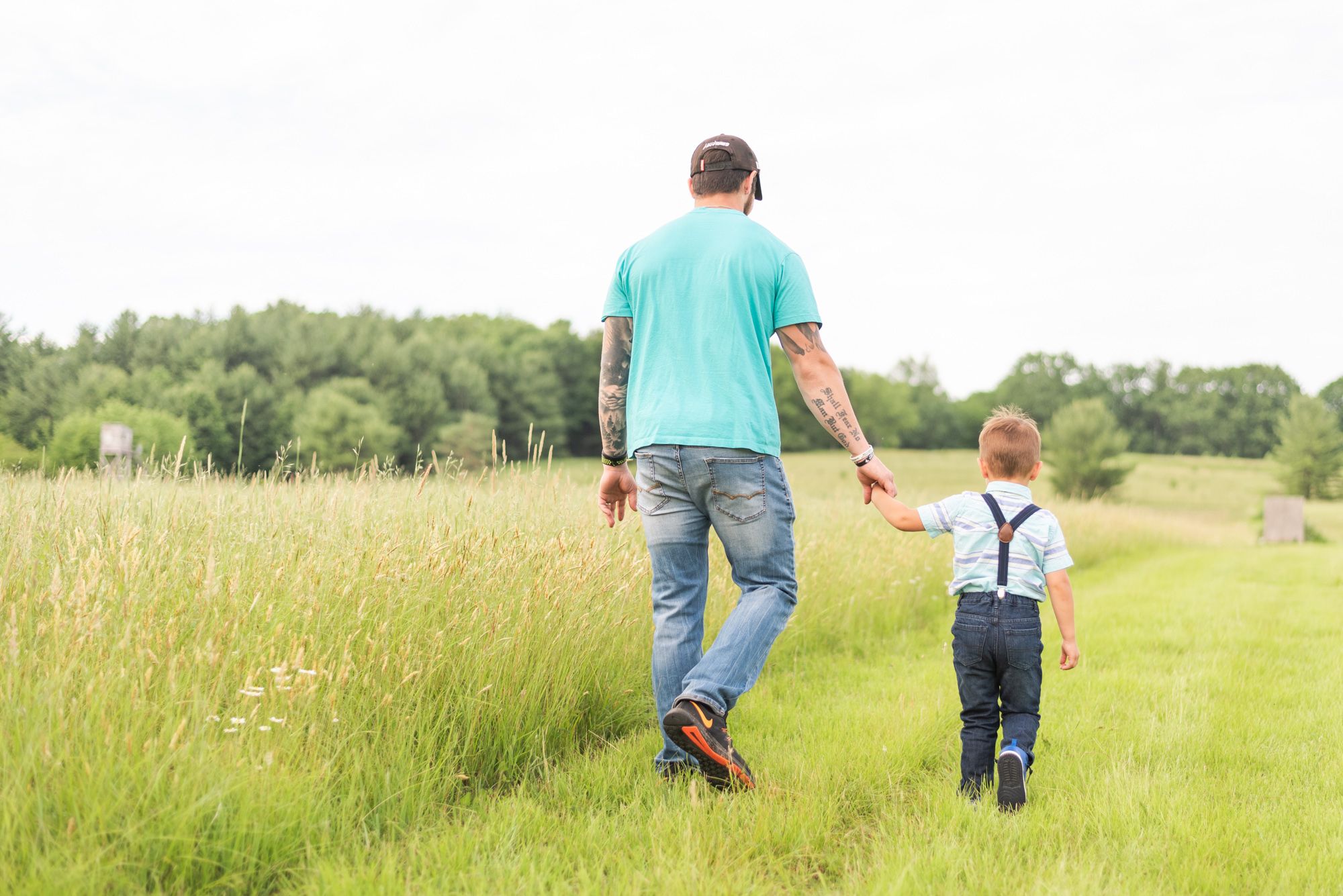 Father and son walking away through field in Clarion Pennsylvania