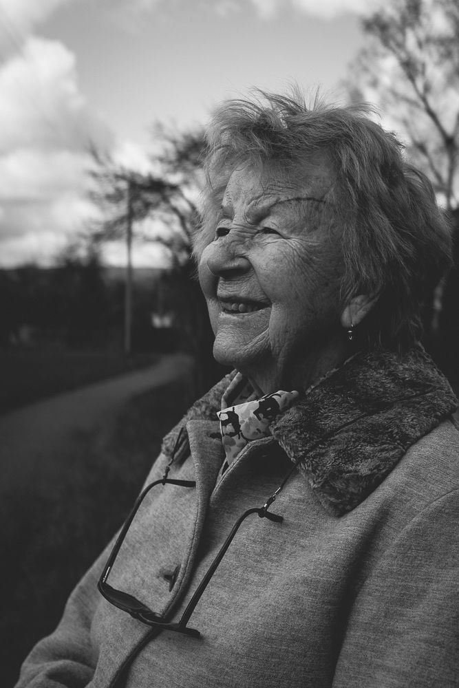 Joyful expression captured in natural outdoor setting with dramatic sky.