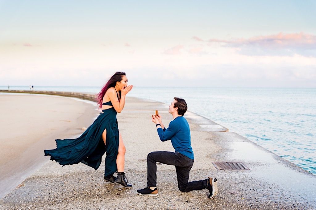 woman is shocked to see her boyfriend on one knee proposing on North Avenue Beach