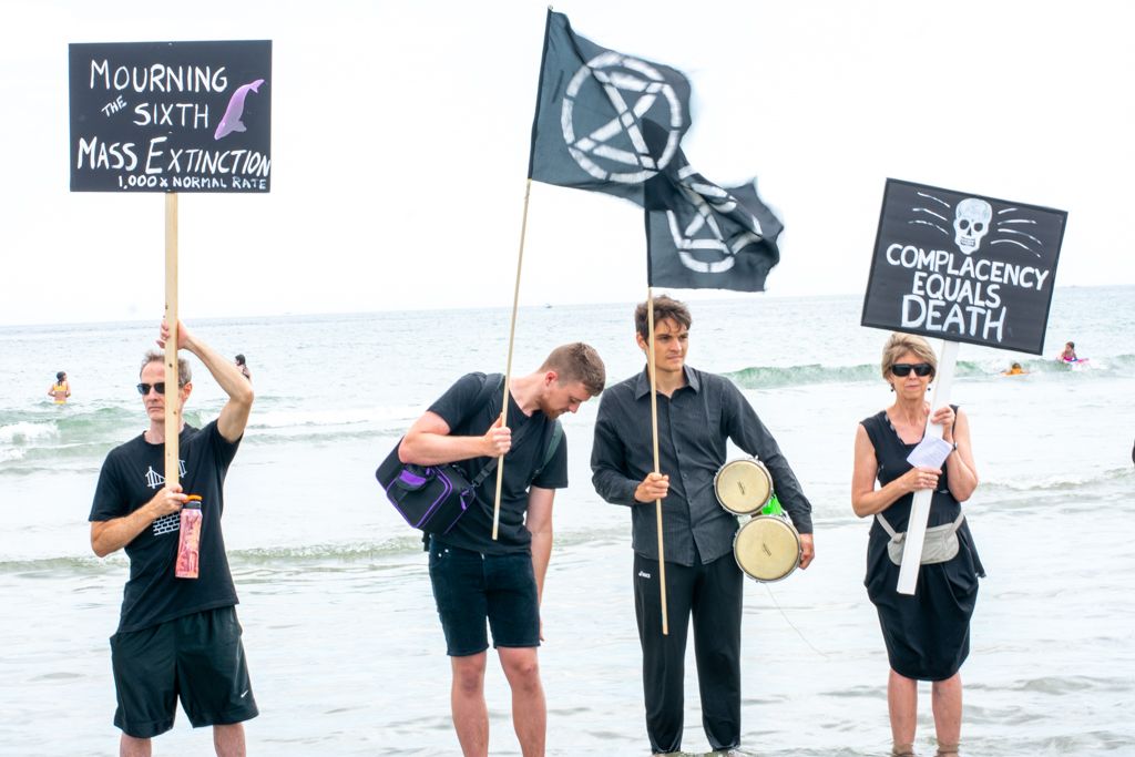 Extinction Rebellion protesters warn beach goers of the climate emergency at Good Harbor Beach in Gloucester, MA