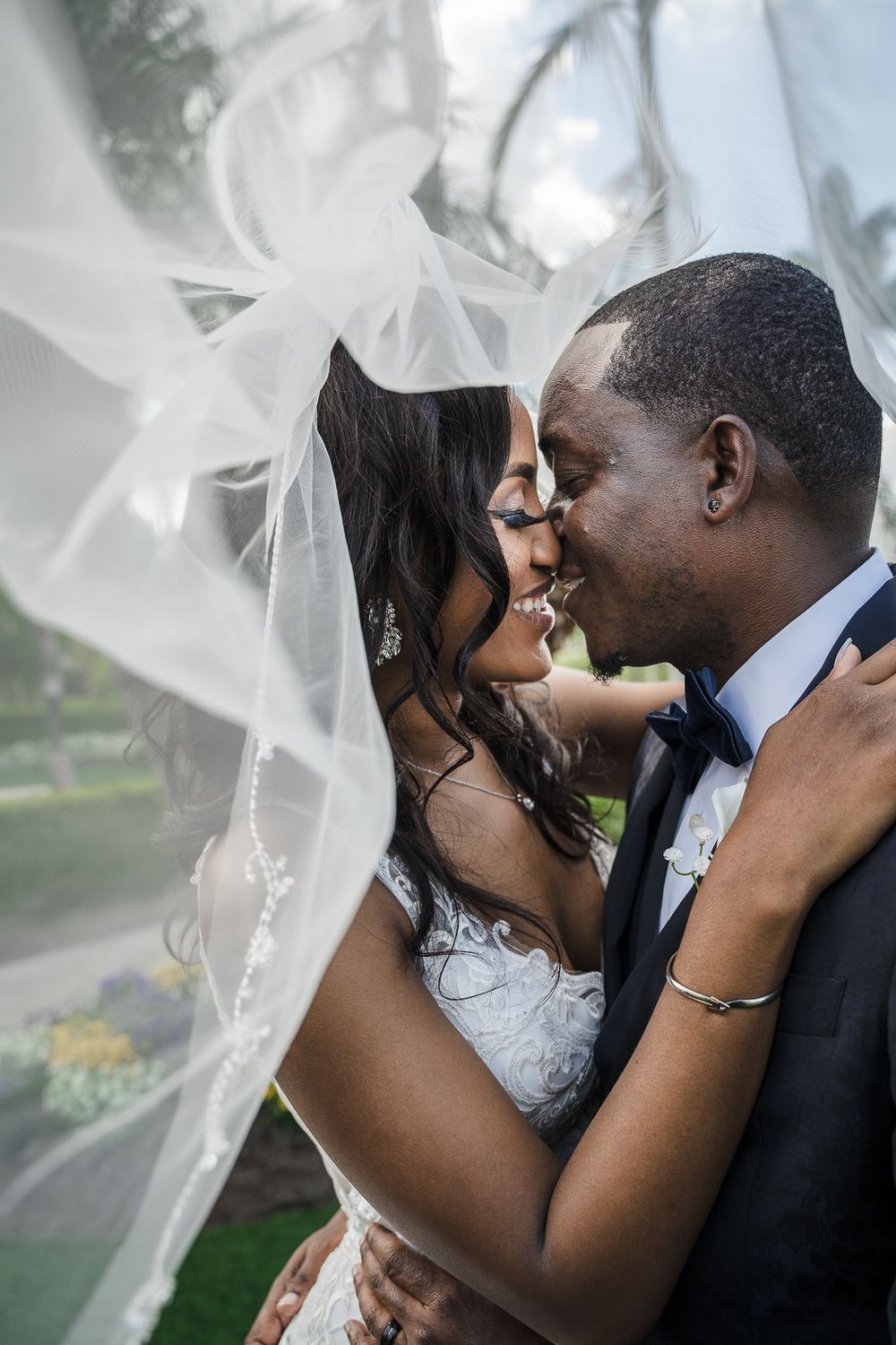 Stunning couple embracing underneath of a wedding veil.