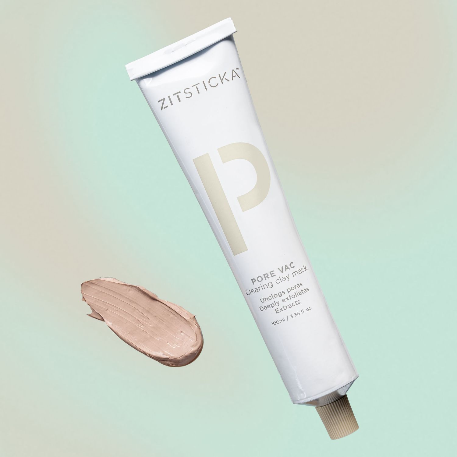 Zitsticka skincare tube with beige product swatch on mint green background.