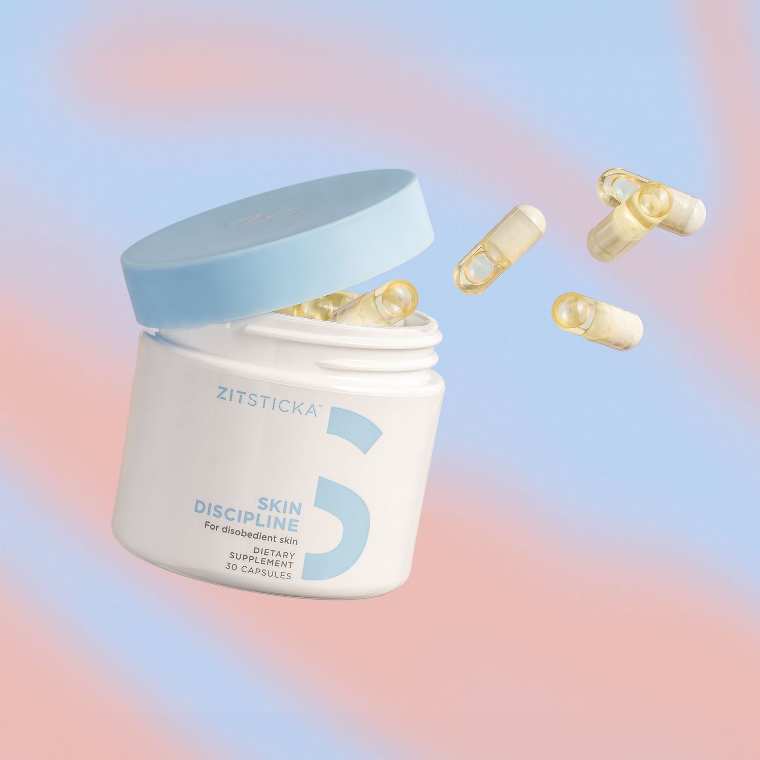White jar of skincare supplements with gold capsules on coral and blue gradient background.