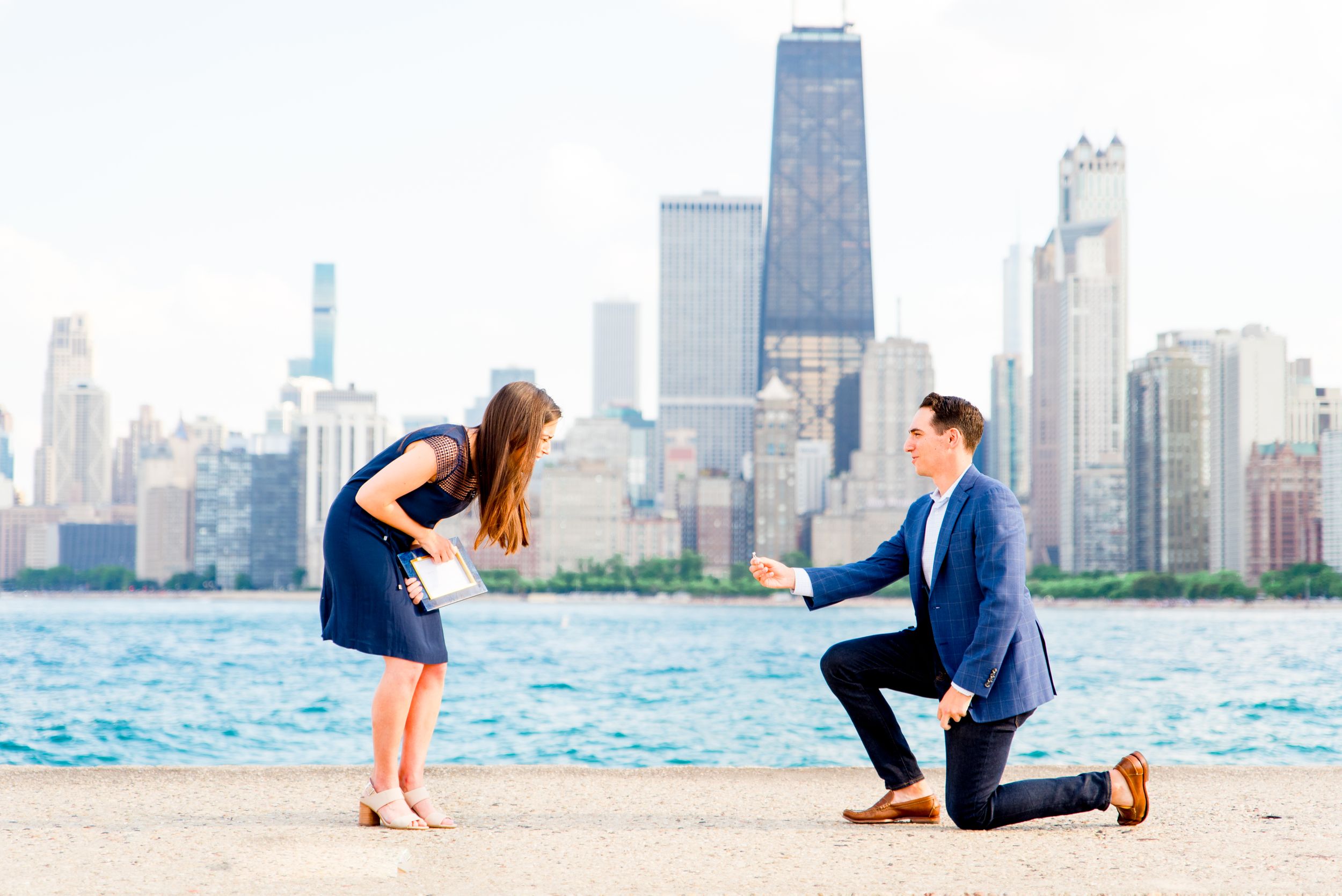 man on one knee proposing at North Avenue Beach in Chicago