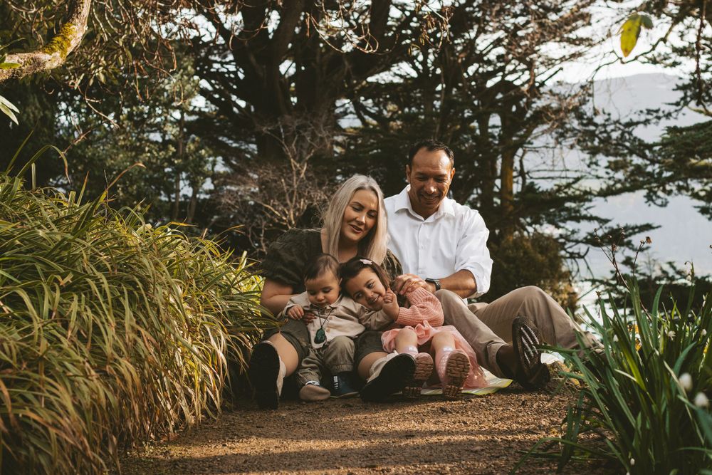 A family enjoys a peaceful moment together on a garden path surrounded by tall grasses.