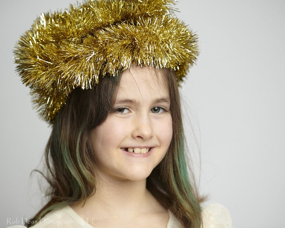 portrait of girl wearing headdress made of gold garland from the Christmas tree