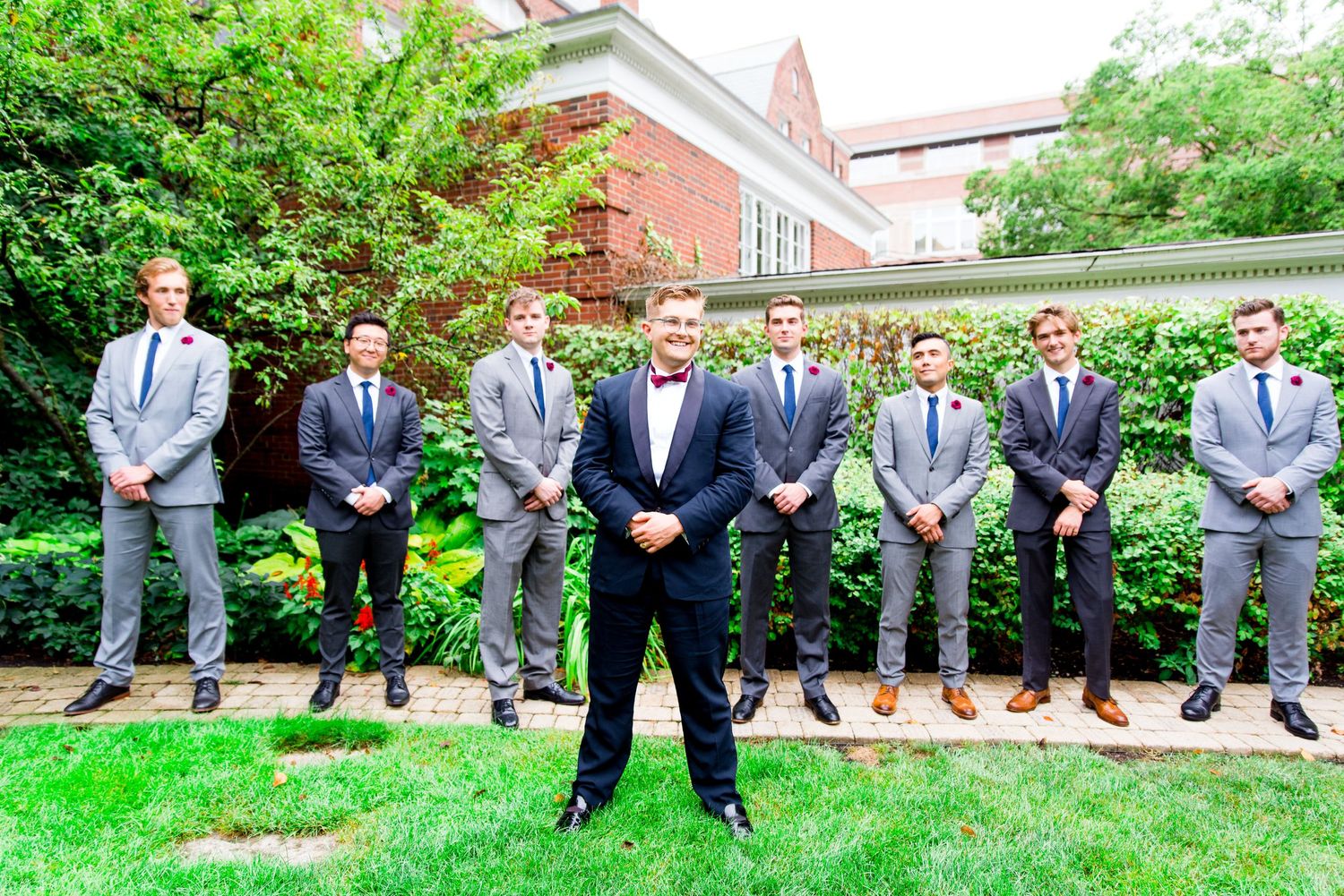 groom standing with all his groomsmen in gray suits in the garden at Woman's Club of Evanston