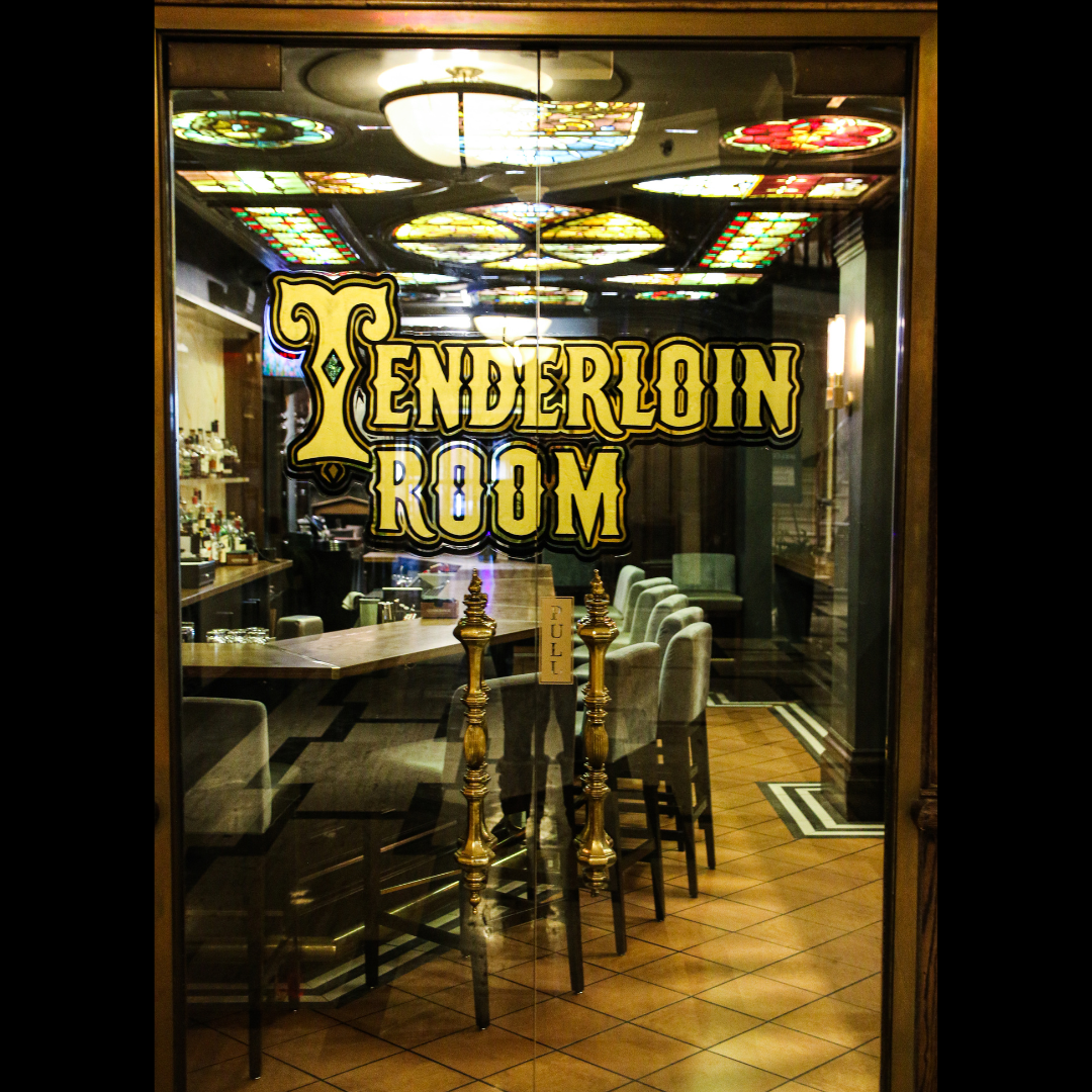 Interior view of a retro-style restaurant entrance with Tenderloin Room sign in gold lettering.