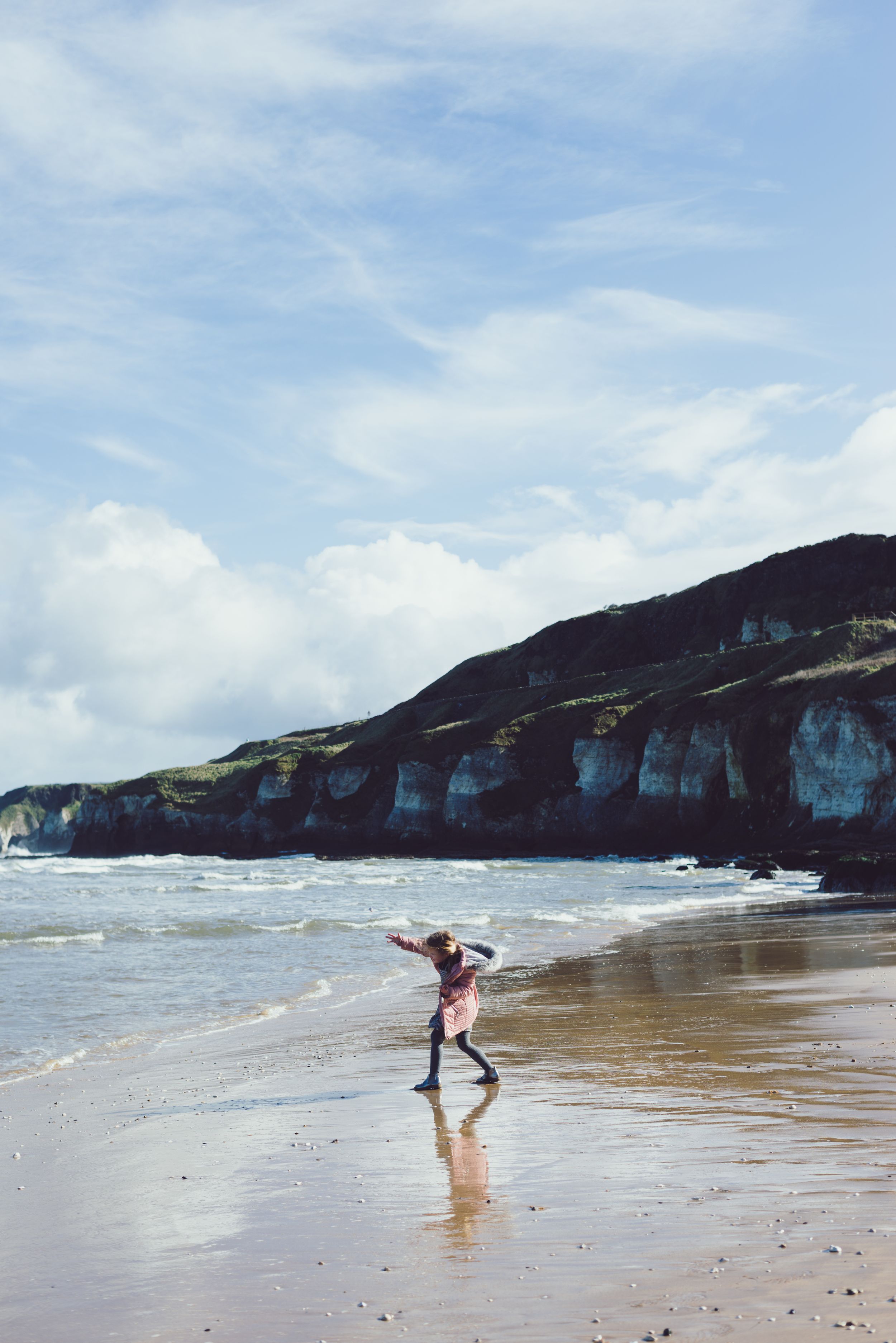young girl playing at the whiterocks beach portrush during a ballymoney family photographer family session
