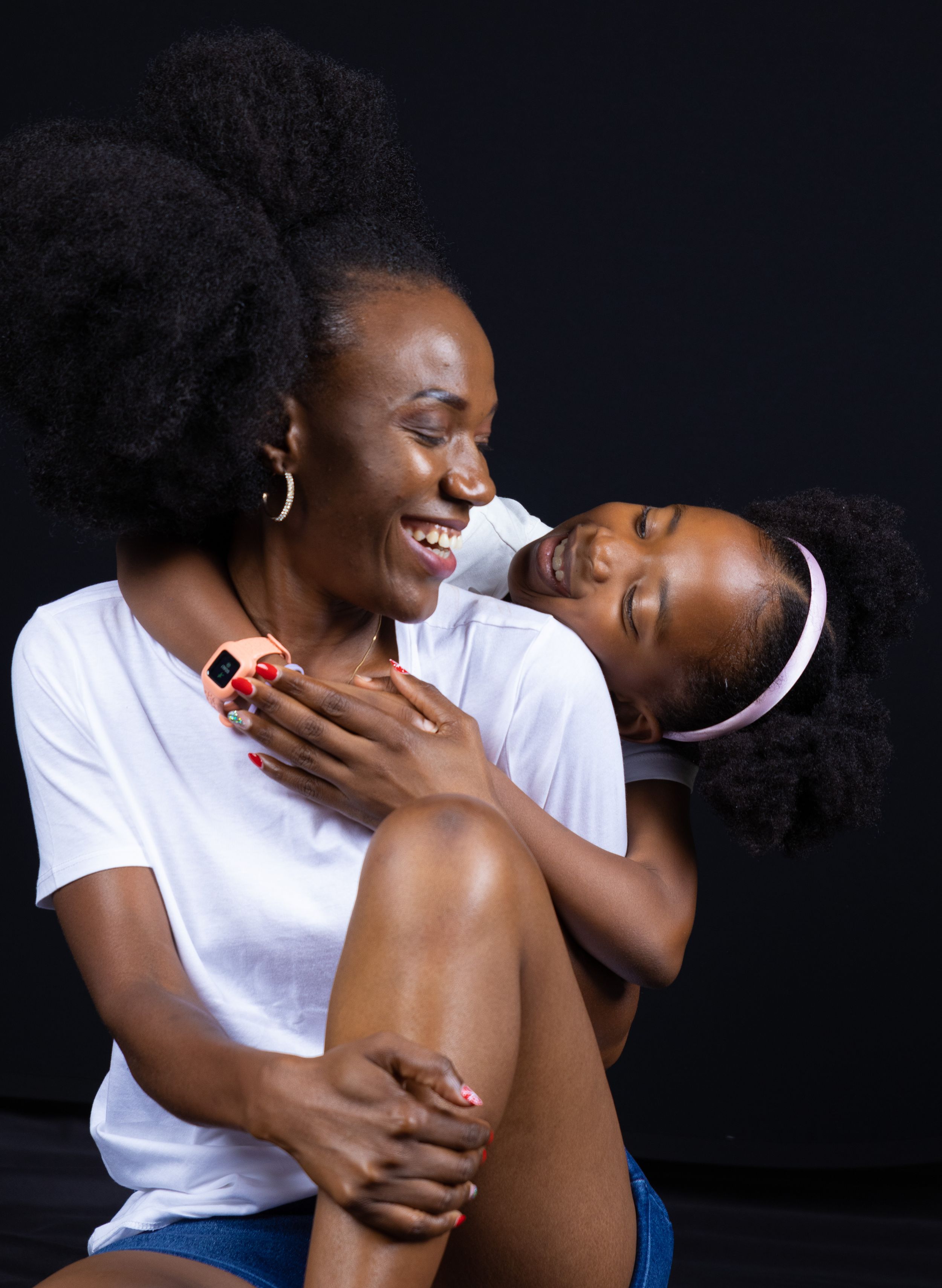 Joyful candid moment captured during intimate photoshoot against black backdrop.