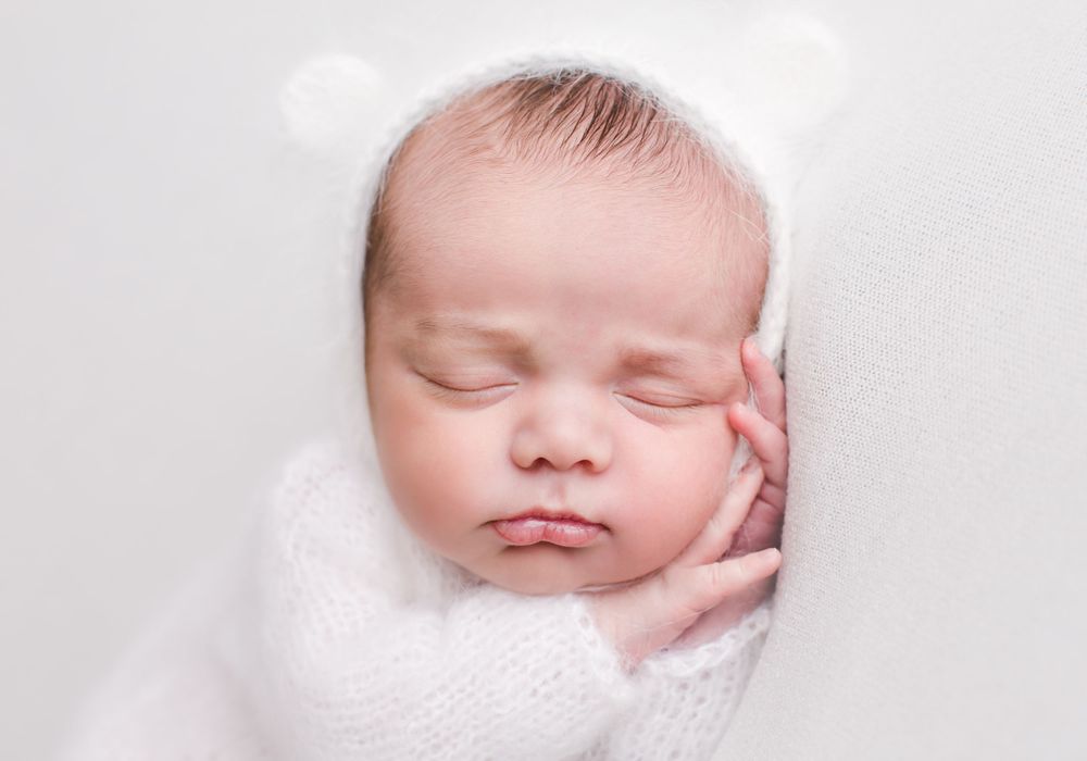 Newborn baby posed sleeping on white back drop - newborn photographer in penticton bc