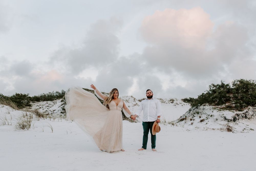 dramatic dress throw by bride in the sand dunes