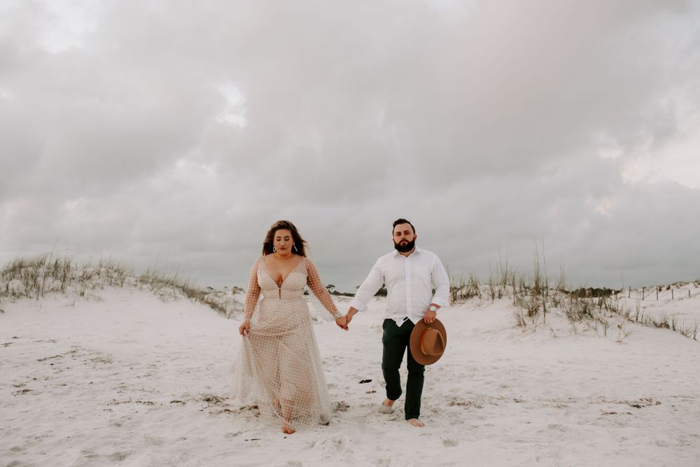 couple running in the sand dunes