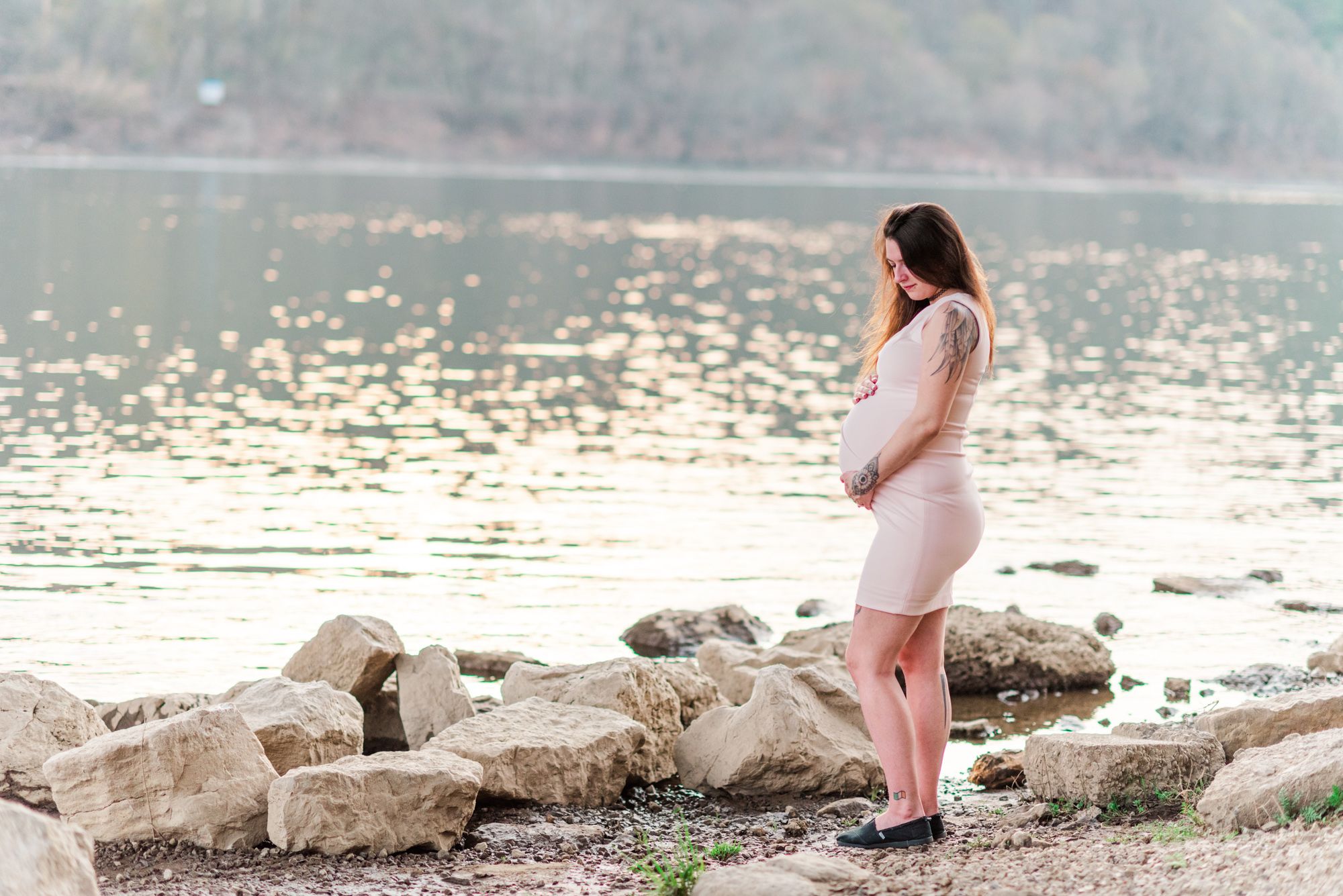 Maternity photos with tattoos in golden hour sunlight by river in Kittanning, Pennsylvania