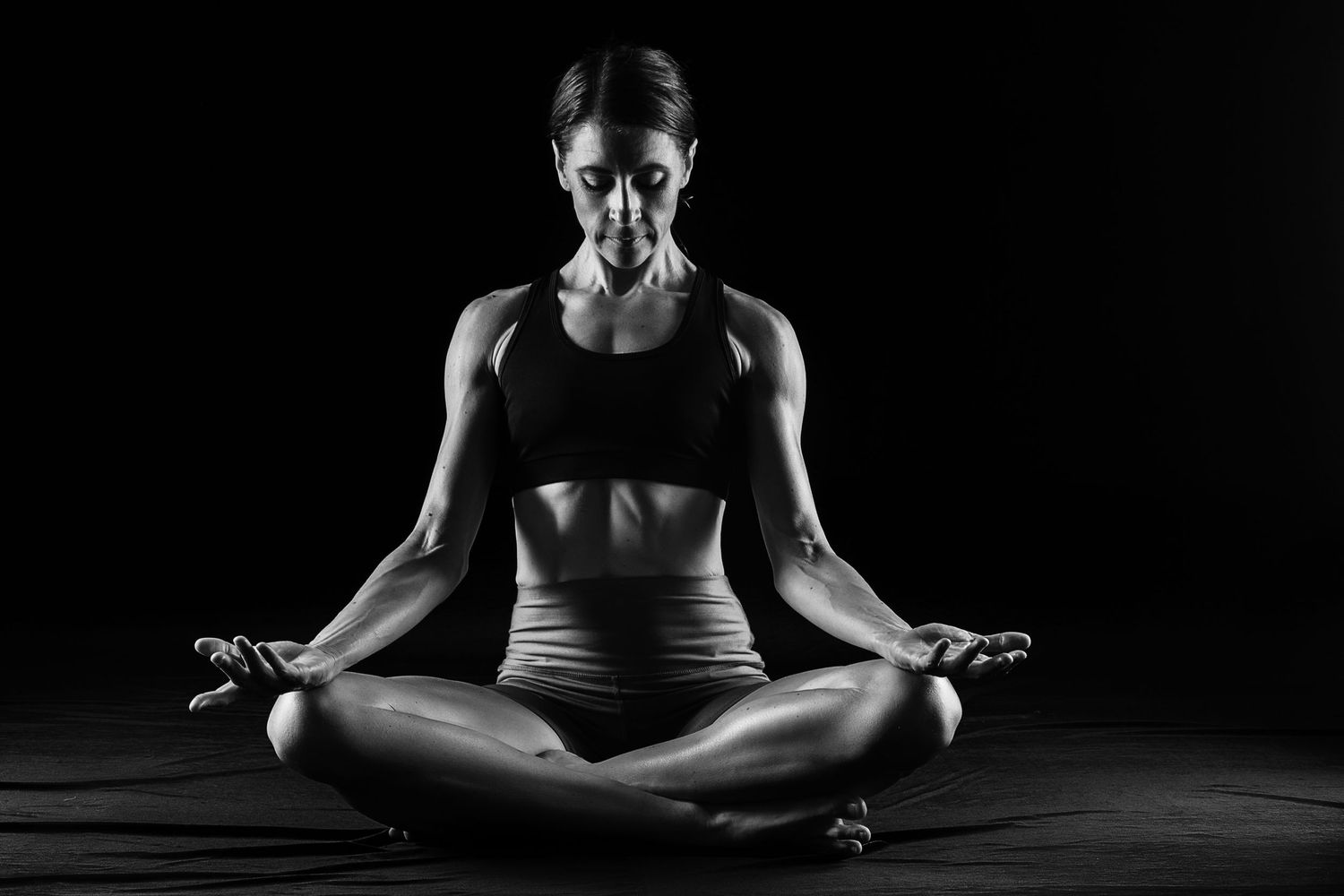 Low key photography of the athletic woman showing a muscular body. Taken by Anastasia Sokyrka based in Ho Chi Minh City