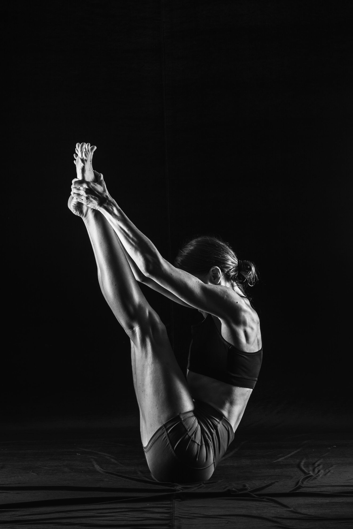 Low key photography of the athletic woman showing a muscular body. Taken by Anastasia Sokyrka based in Ho Chi Minh City