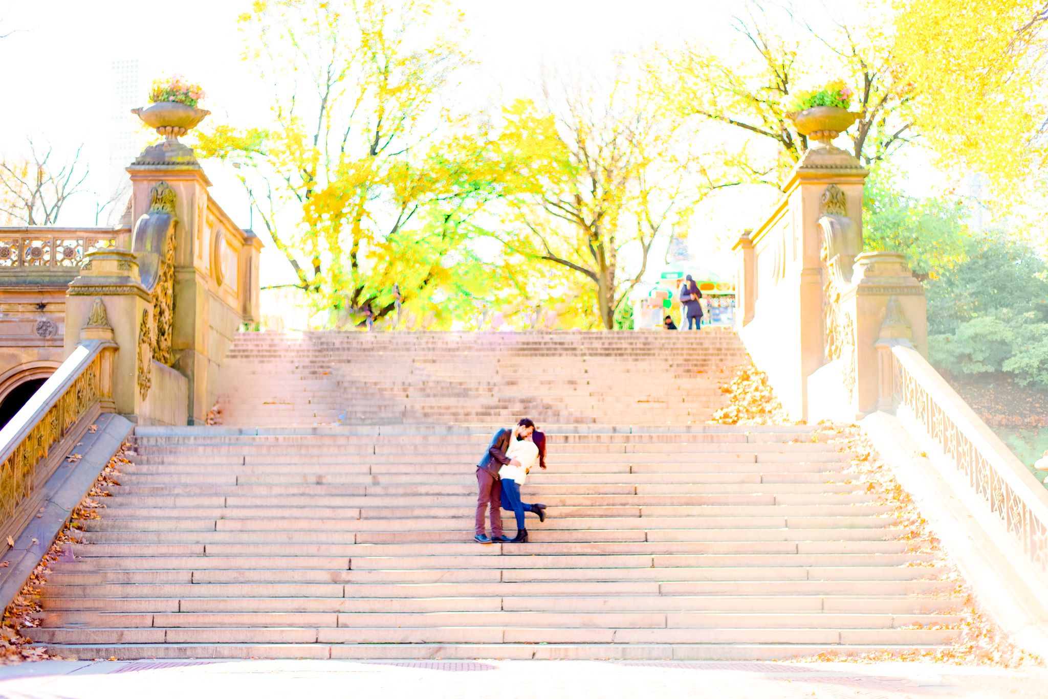 man and woman hugging and dipping in the middle of stairs at Bethesda Terrace in Central Park for sunrise engagement