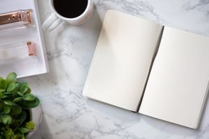 Styled stock desk scene with coffee, notebook and rose gold office supplies