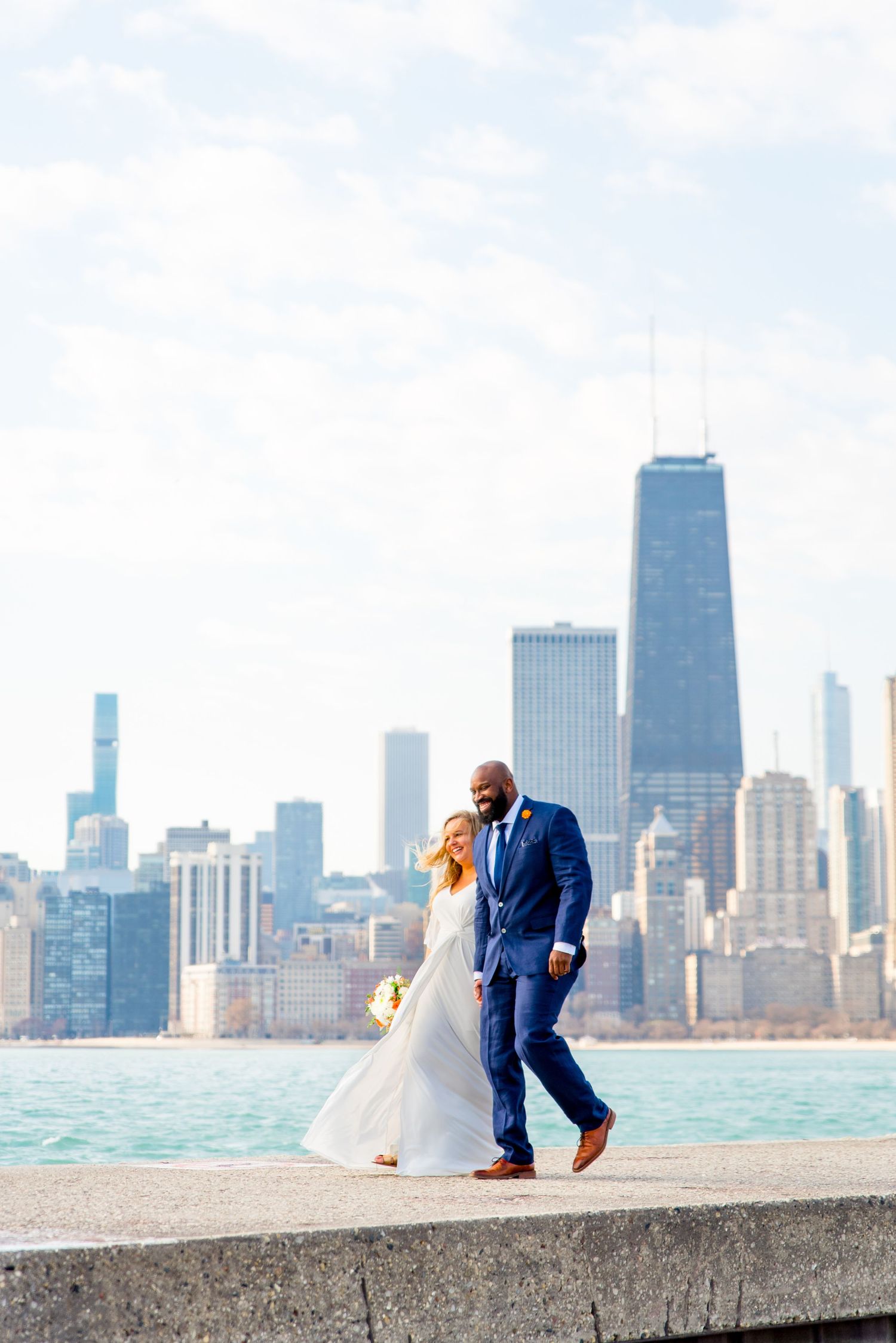 man and woman just got married at north avenue beach walking taking wedding photos