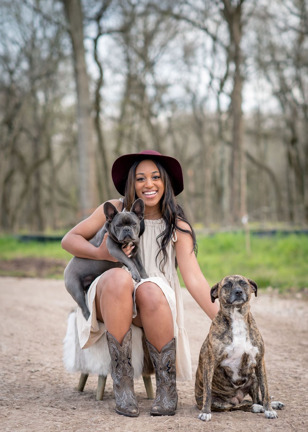 RidgePoint High School Senior Girl in a Burgundy Hat, Beige Dress, and Cowboy boots with her dogs in Sienna