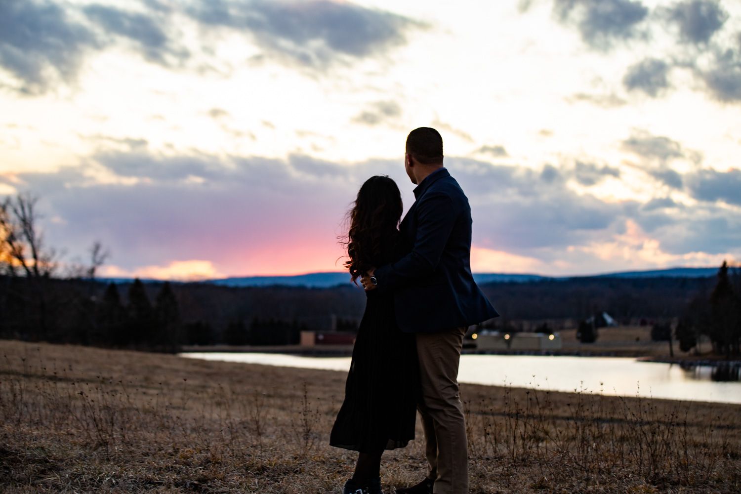 Engaged couple watch the sunset over Watchtower Farms in Wallkill, New York