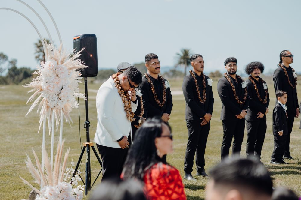 Wedding party standing at the altar with decorative pampas grass arrangements.