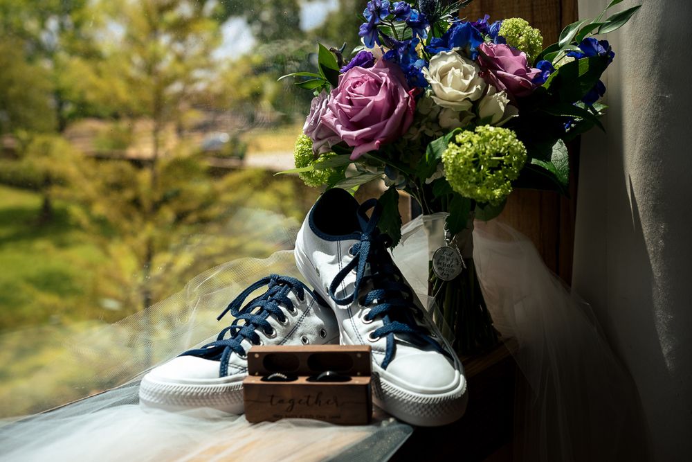 bride shoes, flowers and rings sitting on the window sill