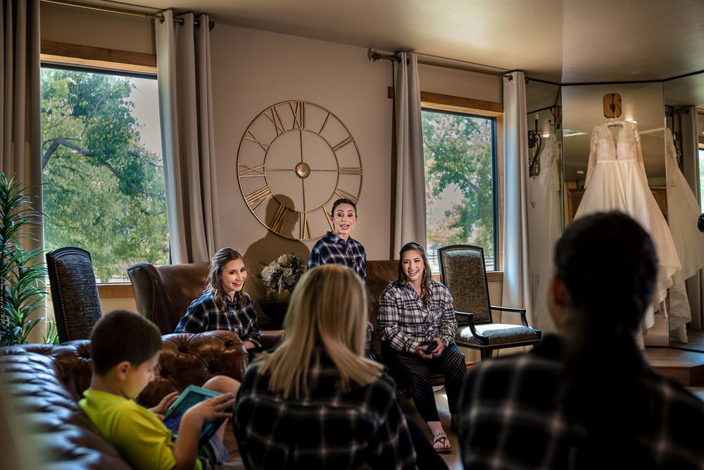 bride and wedding party talk together while sitting on couches