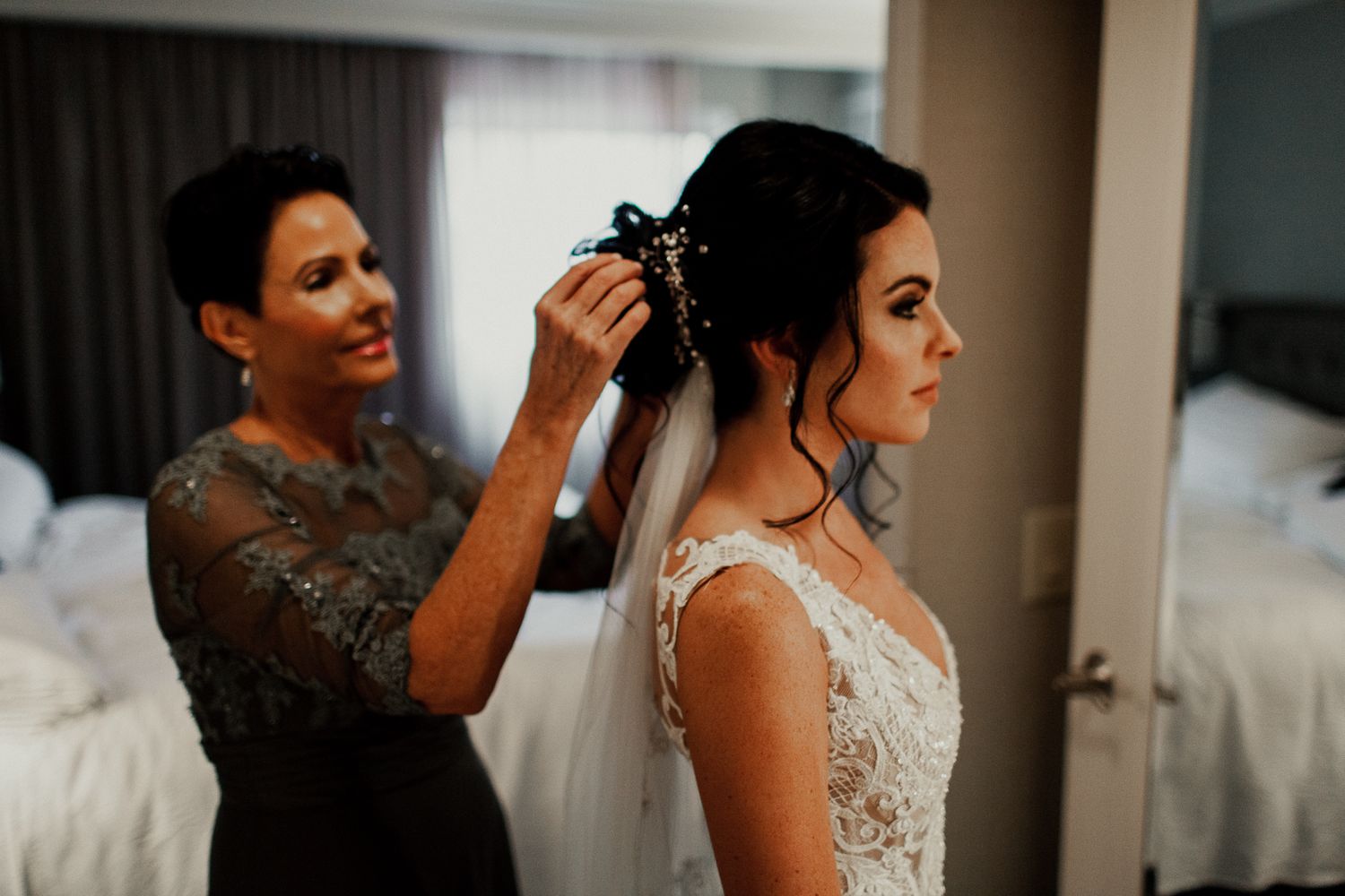 mother of bride adjusting veil for bride