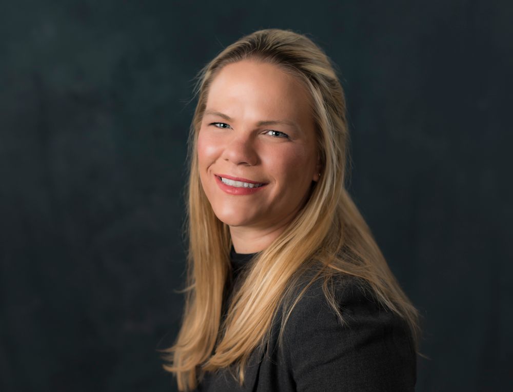 Headshot portrait of woman with black background