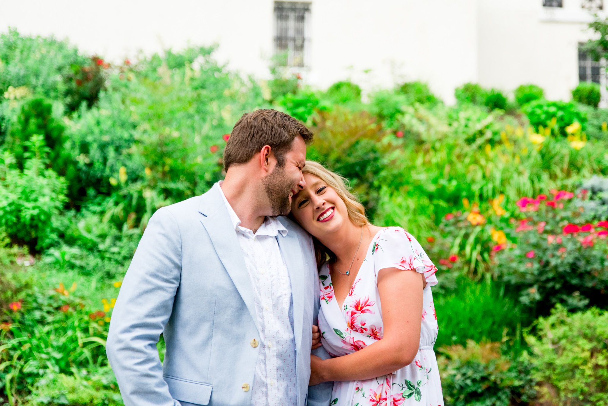 blonde woman hugging arm of man with short brown hair on a rainy day in Louisville for engagement pictures
