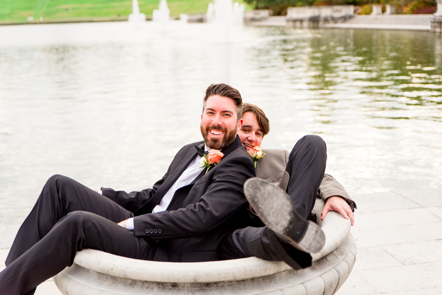groom and groomsmen sit in bird bath at STL Forest Park groomsmen portraits