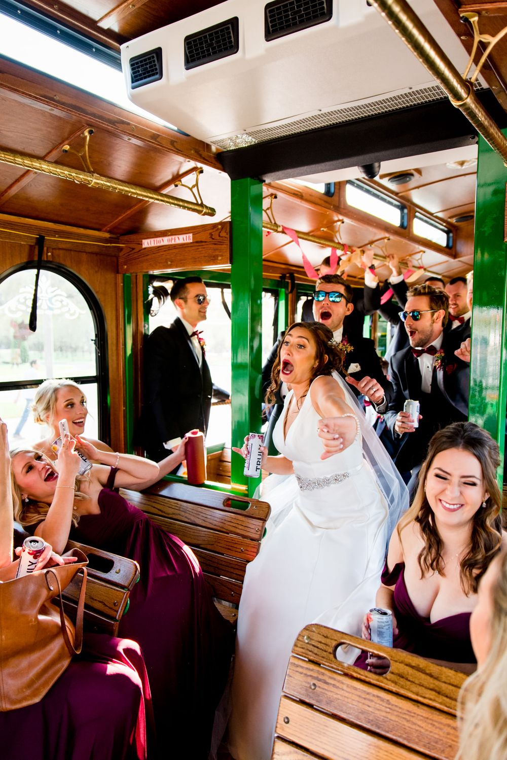 laughing wedding party dances on trolley after fall chicago wedding