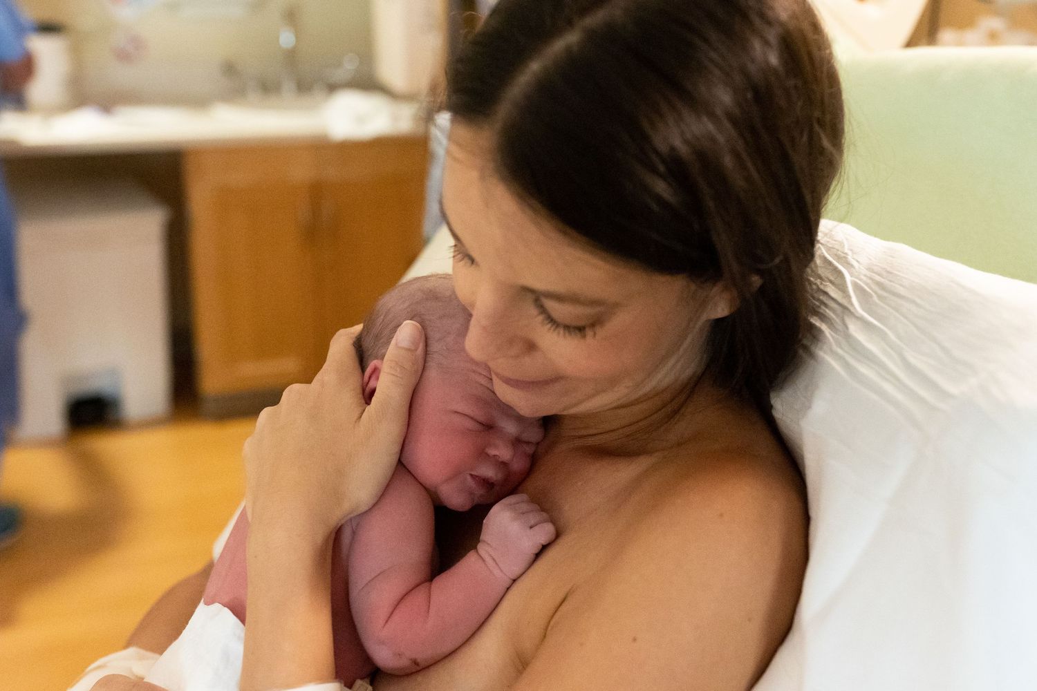 Mom snuggles her newborn baby in Lafayette, CO
