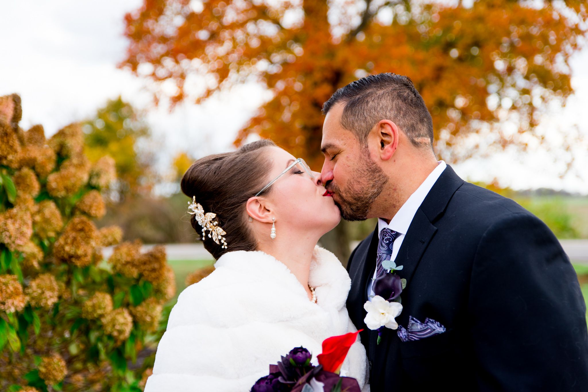 bride and groom kissing and smiling in front of orange tree at the Shepard's Place wedding