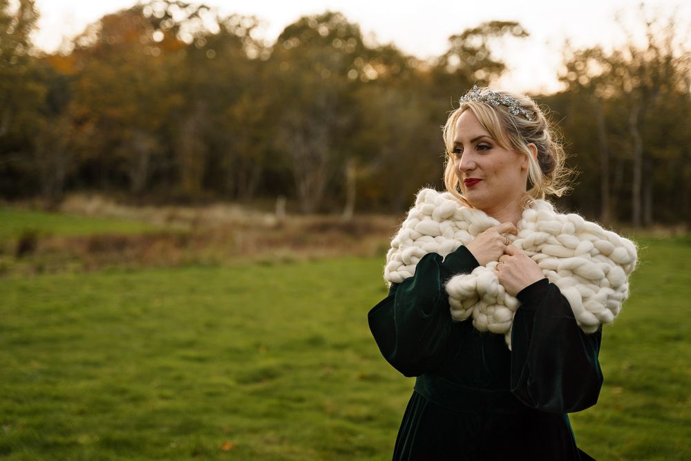 Bride snuggles up in a cosy wool shawl at her Hampshire winter wedding.