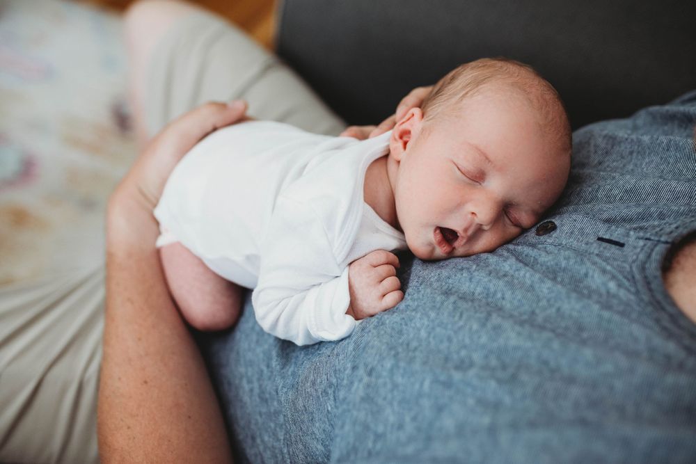 baby sleeping on dads chest by boston newborn photographer