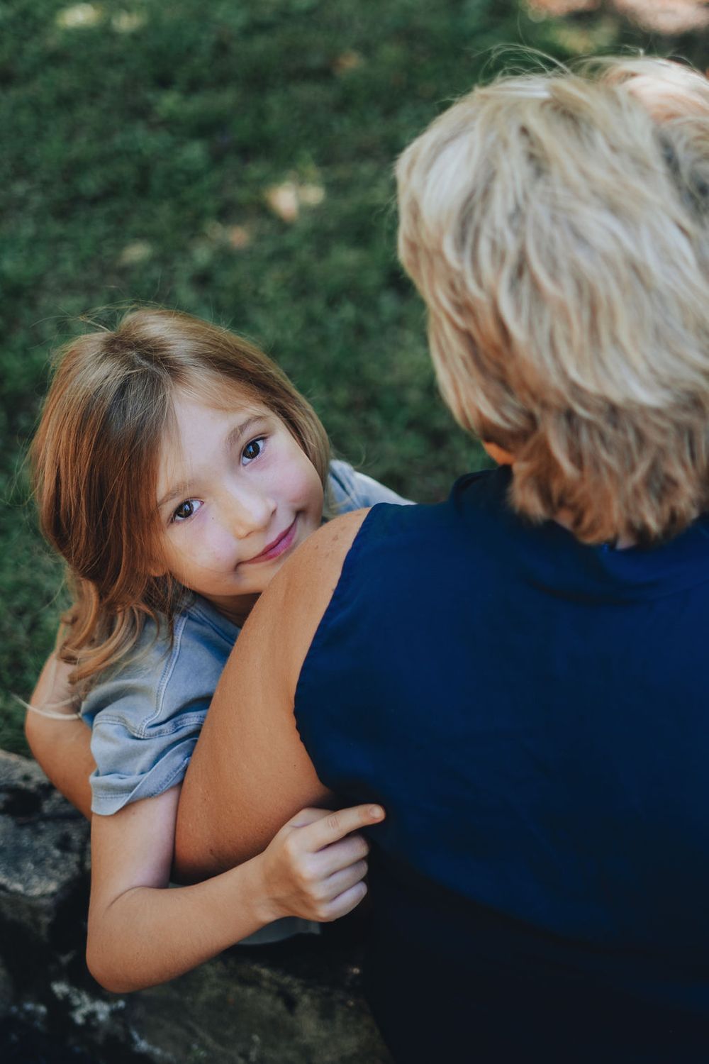 Granddaughter hugging grandmother at park in Hamilton, New Jersey during intimate special moments session