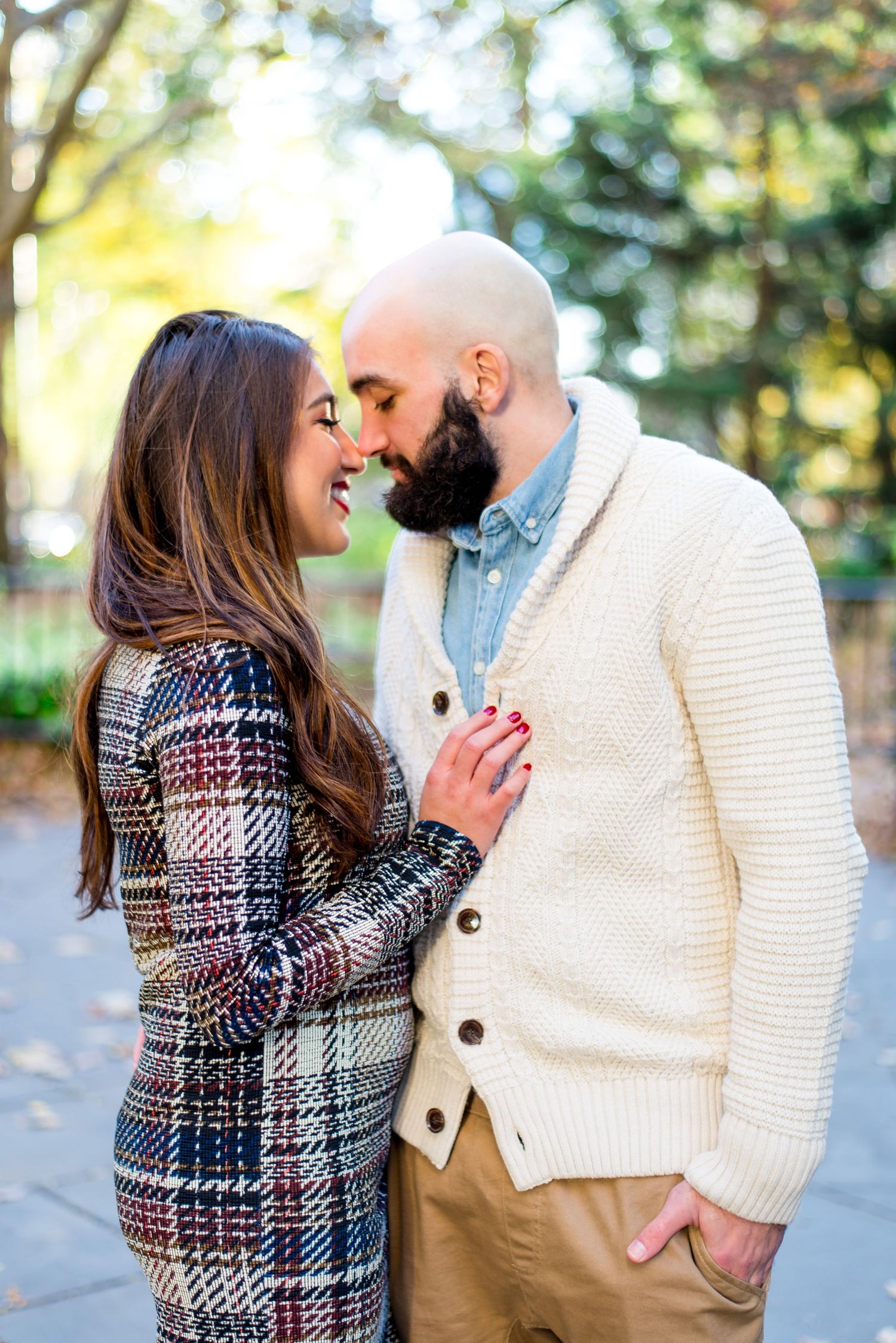 engaged couple is nose-to-nose and smiling for engagement pictures at New York City Hall