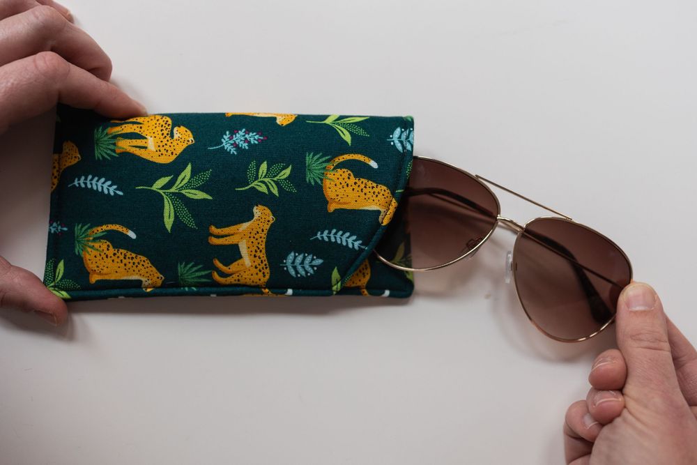 Lifestyle product photography image of sunglasses case, and sunglasses.