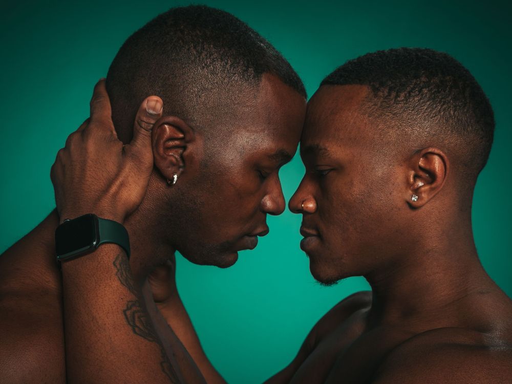 An artistic portrait of tenderness and connection against an emerald backdrop.